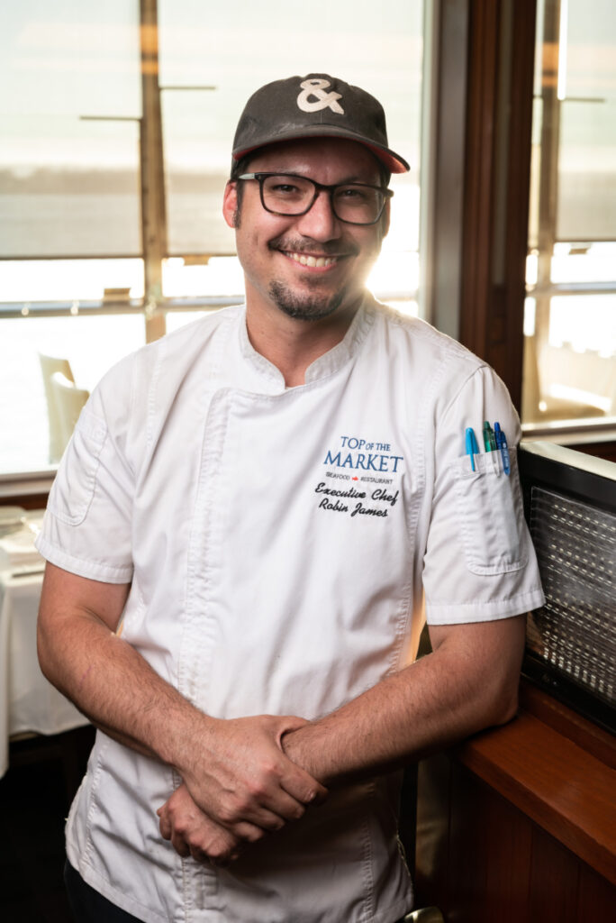 Executive Chef Robin James smiles for the camera with the sun setting in the background